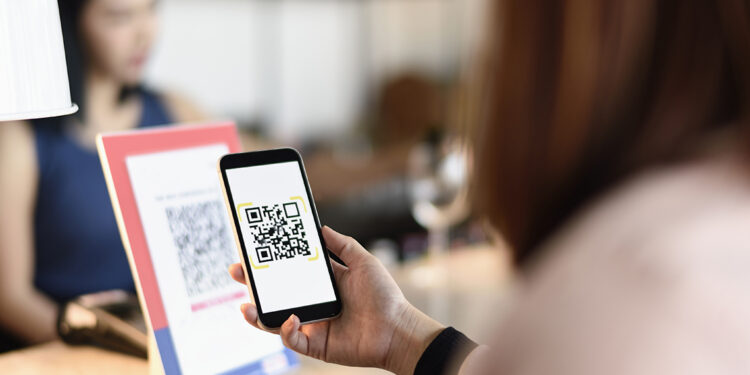 A woman holding a smartphone accessing a QR code